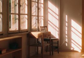 Sunlight streams into a cozy room with a desk.