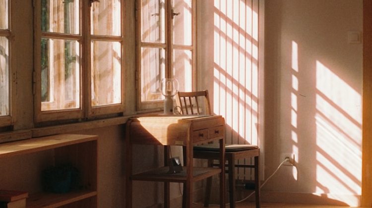 Sunlight streams into a cozy room with a desk.