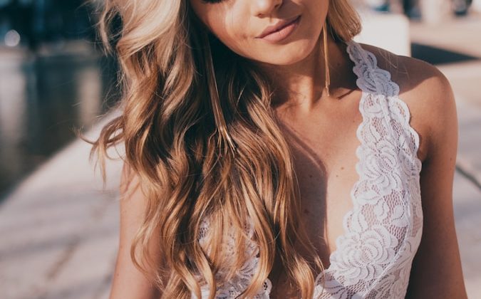 woman wearing lace halter top and blue denim jeans