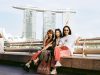 Three women pose with marina bay sands.