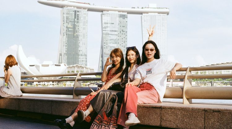 Three women pose with marina bay sands.