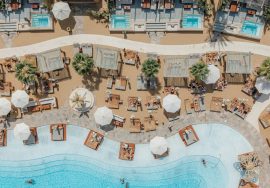 A luxury beach resort with pools and loungers.