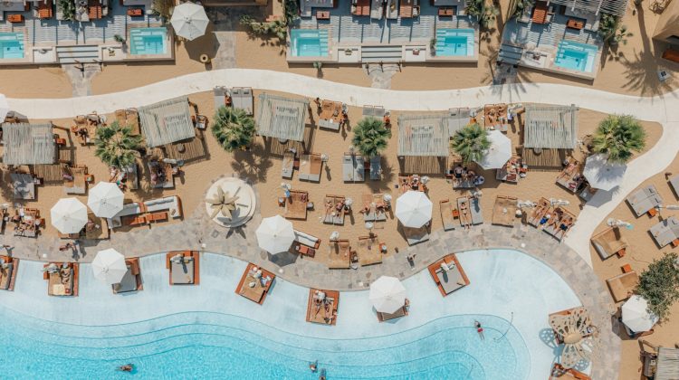 A luxury beach resort with pools and loungers.