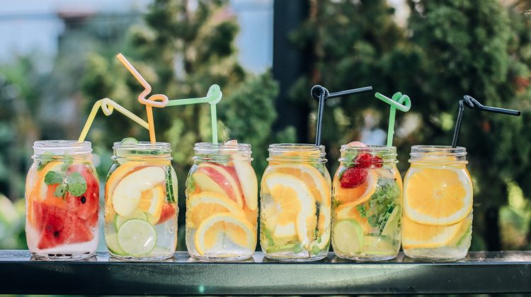 six clear glass mason jars filled with juice on black table