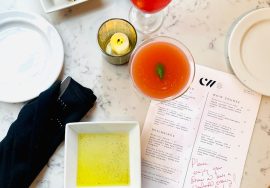 Cocktails, bread, and menu items displayed on a table.