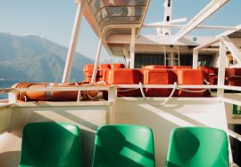 On a boat with seats and life preservers.