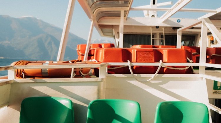 On a boat with seats and life preservers.