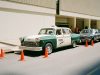 A vintage taxi parked near some traffic cones.
